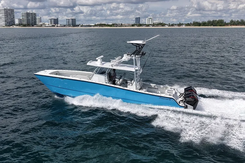 Slide: The Image of 2024 Freeman 42LR boat cruising on open water near a city skyline. - 5