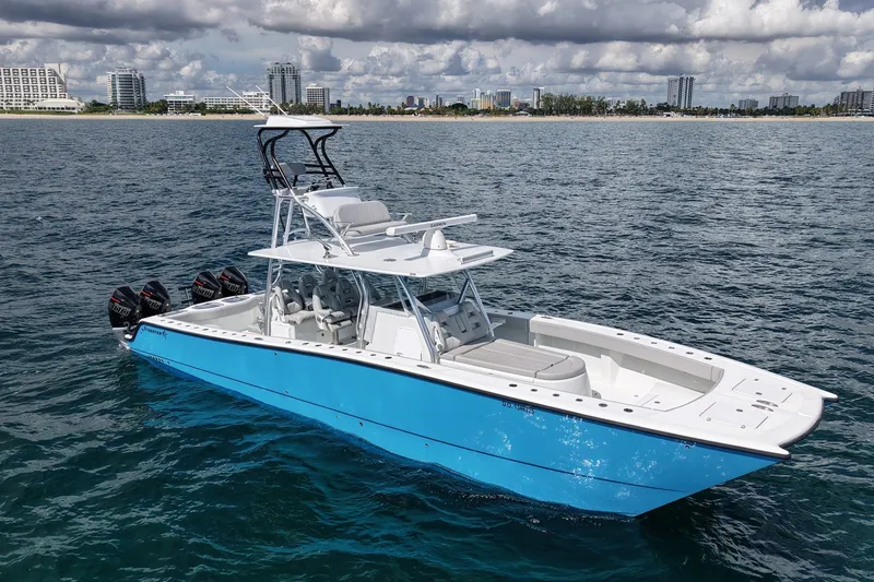 Slide: The Image of 2024 Freeman 42LR boat on ocean, blue hull, multiple outboard engines, city skyline background. - 1