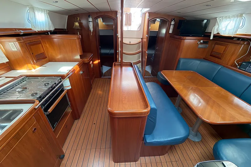 Slide: The Image of Interior of 2001 Beneteau 50 yacht with wood finish and blue seating. - 4