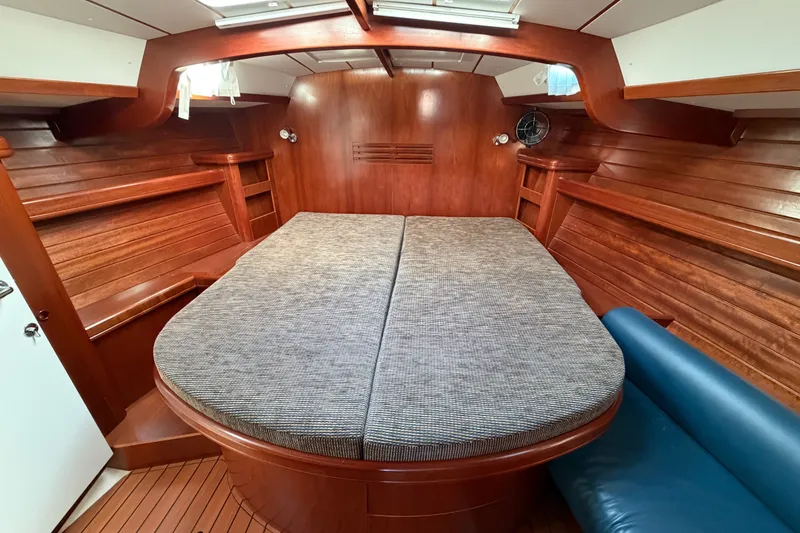 Slide: The Image of Luxurious cabin interior of a 2001 Beneteau 50 yacht with wooden finish and cozy bedding. - 11