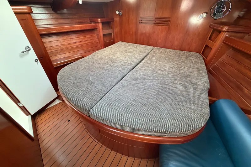 Slide: The Image of Cabin interior of 2001 Beneteau 50 yacht with wooden finish and comfortable bedding. - 12