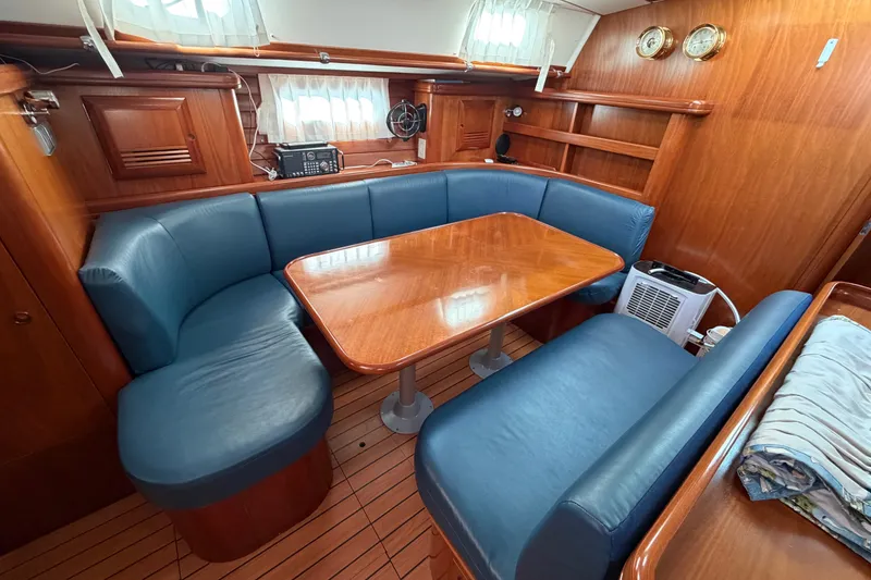 Slide: The Image of Luxurious interior of a 2001 Beneteau 50 yacht with blue seating and wooden table. - 5