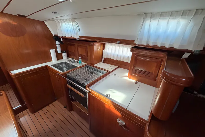 Slide: The Image of Galley kitchen in 2001 Beneteau 50 yacht with wood cabinetry and stainless steel sink. - 9