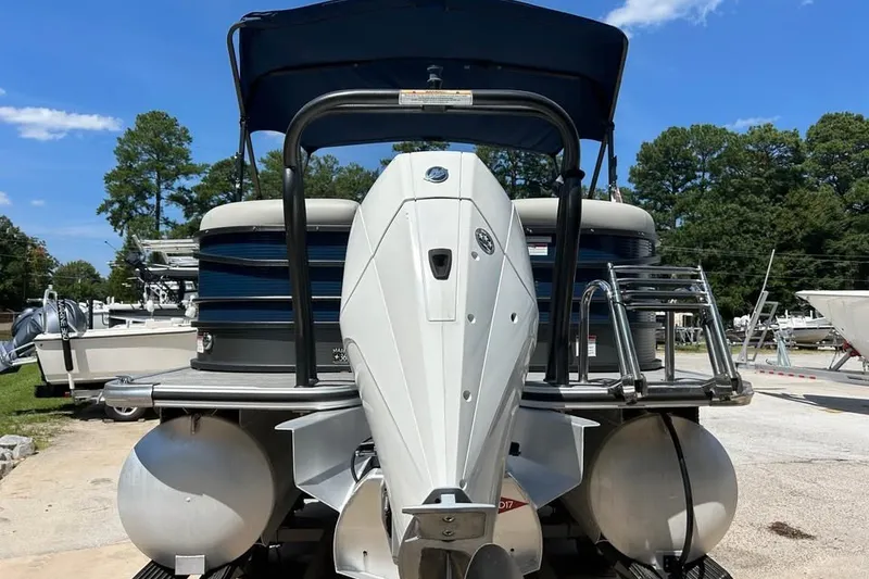 Slide: The Image of 2019 Crest Classic 230 SLC pontoon boat with outboard motor, parked outdoors. - 4