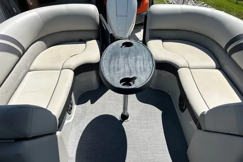 Slide: The Image of 2019 Crest Classic 230 SLC boat interior with curved seating and central table. - 10