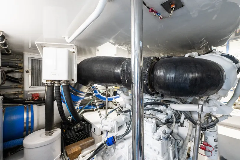 Slide: The Image of Engine room of 2005 Hatteras 60 Convertible yacht, showcasing mechanical components and piping. - 48