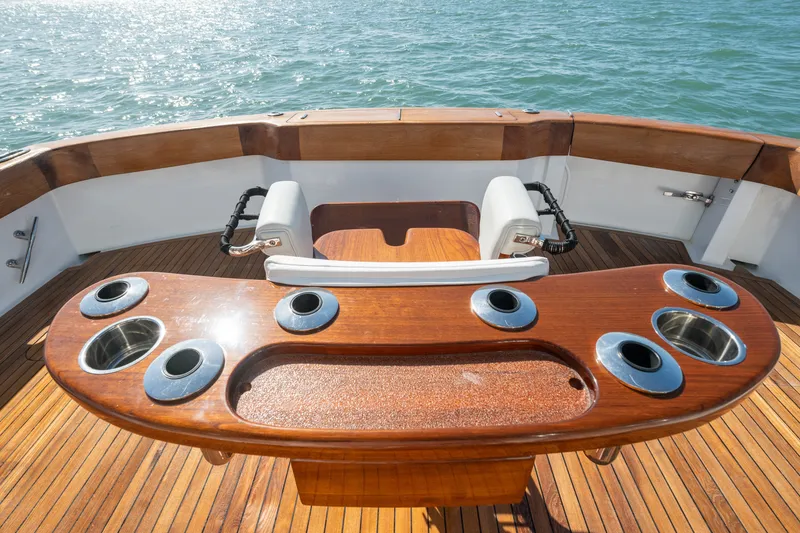 Slide: The Image of Luxury fishing deck on 2005 Hatteras 60 Convertible yacht, featuring teak wood and rod holders. - 43