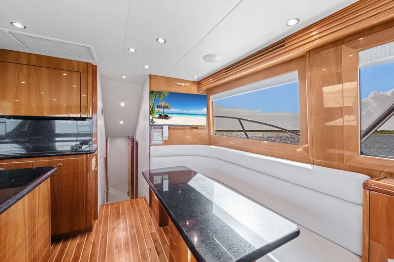 Slide: The Image of Luxurious interior of 2005 Hatteras 60 Convertible yacht with elegant wood finishes and panoramic windows. - 7