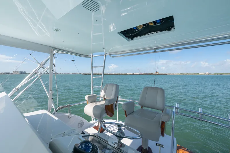 Slide: The Image of 2005 Hatteras 60 Convertible yacht helm with ocean view and seating. - 35