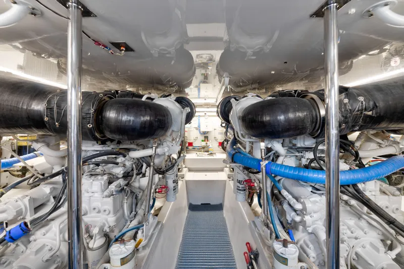 Slide: The Image of Engine room of a 2005 Hatteras 60 Convertible yacht, showcasing dual engines and mechanical components. - 45