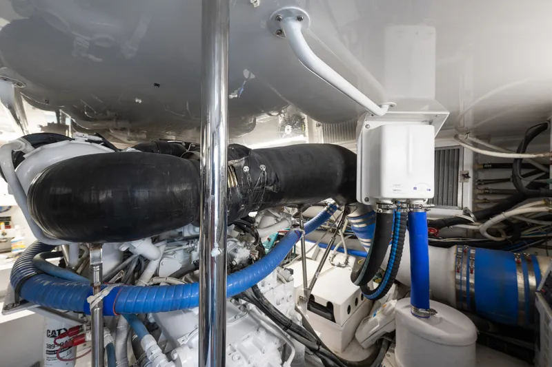 Slide: The Image of Engine room of a 2005 Hatteras 60 Convertible yacht, showcasing complex machinery and piping. - 49