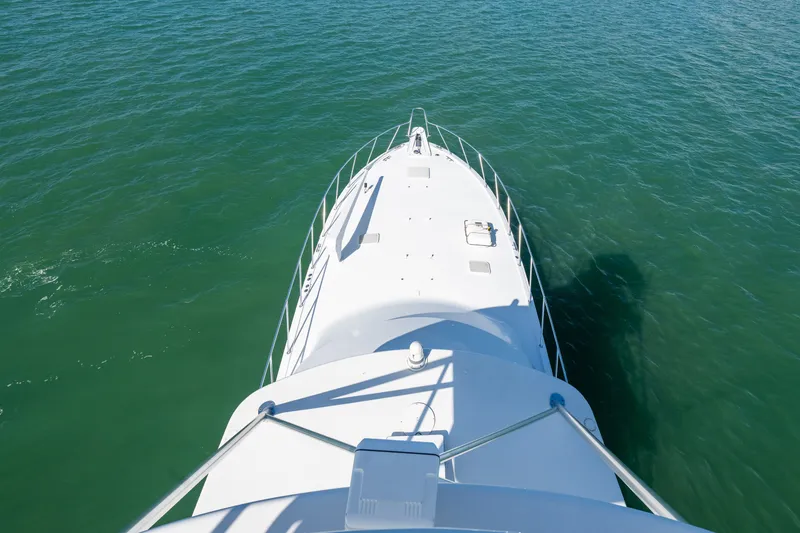 Slide: The Image of Bow view of 2005 Hatteras 60 Convertible yacht cruising on open water. - 38