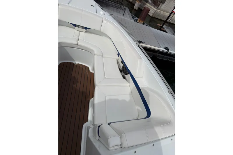 Slide: The Image of 2008 Formula 310 Bowrider boat with white seating and wooden deck, docked at marina. - 12