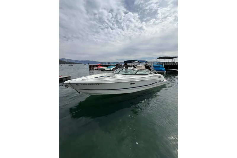 Slide: The Image of 2008 Formula 310 Bowrider boat docked on a calm lake under cloudy skies. - 1