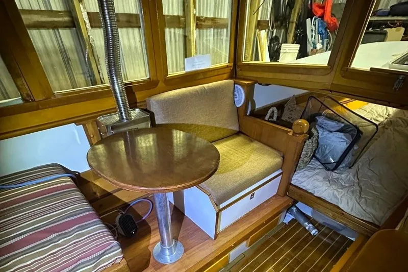 Slide: The Image of Cozy interior of a 1974 Custom Launch boat with wooden furnishings and seating area. - 4
