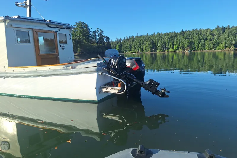Slide: The Image of Custom 1974 launch boat with outboard motor on calm lake, surrounded by lush forest. - 2