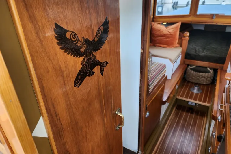 Slide: The Image of Interior of a 1974 custom launch boat with wooden decor and tribal eagle design. - 10