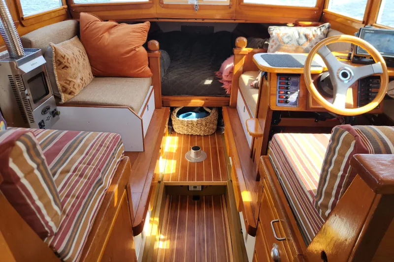 Slide: The Image of Cozy 1974 custom launch interior with striped cushions, wooden accents, and steering wheel. - 6
