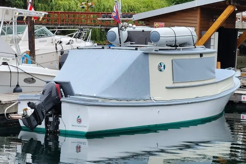 Slide: The Image of Custom 1974 launch boat docked, featuring an outboard motor and covered cabin. - 1
