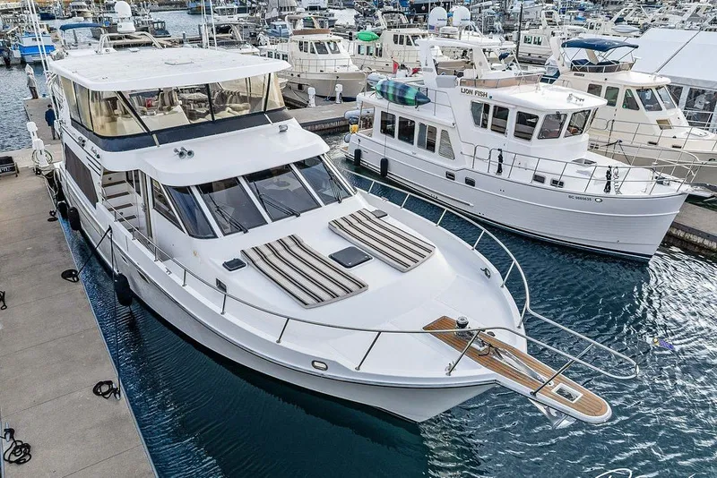 Slide: The Image of 1993 Tollycraft 57 Pilothouse Motor Yacht docked at marina, surrounded by other boats. - 49