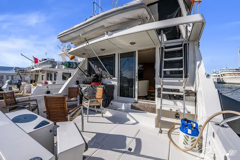Slide: The Image of 1993 Tollycraft 57 Pilothouse Motor Yacht deck with seating and ladder, docked at marina. - 31