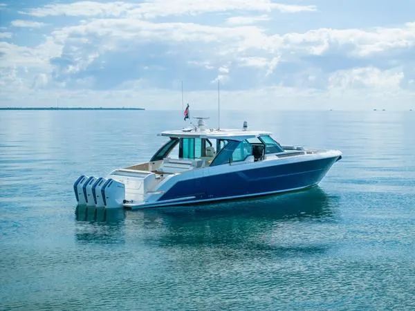 Slide: The Image of 2025 Tiara Yachts 56 LS luxury boat on calm water under a cloudy sky. - 3