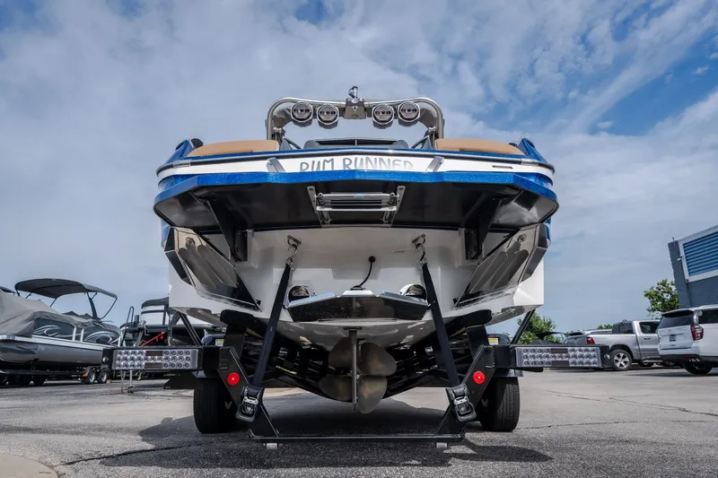 Slide: The Image of 2021 MasterCraft X24 boat on trailer, rear view, under a cloudy sky. - 2