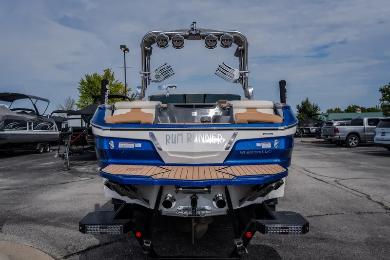 Slide: The Image of 2021 MasterCraft X24 boat, blue and white, parked outdoors, rear view. - 12