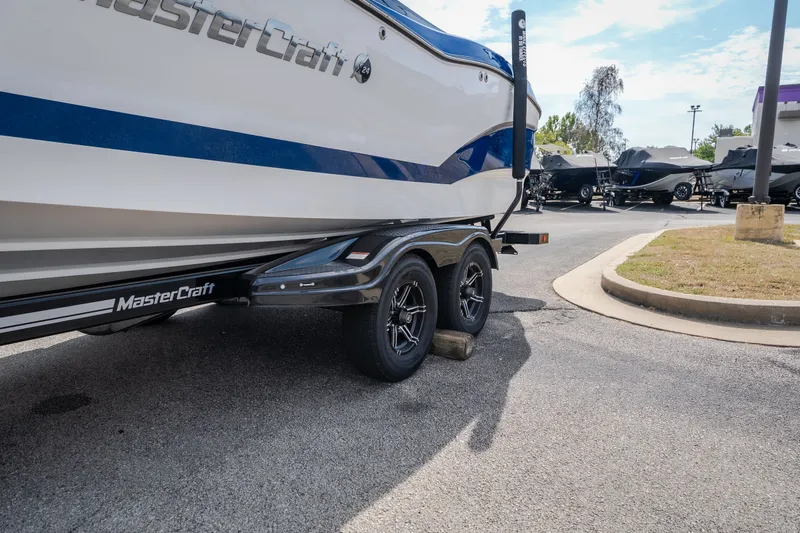 Slide: The Image of 2021 MasterCraft X24 boat on trailer in parking lot, side view. - 51