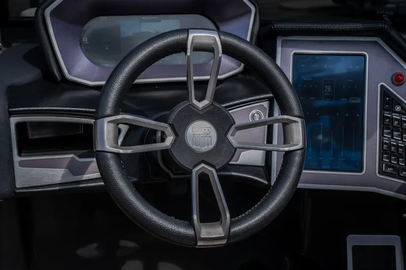 Slide: The Image of Steering wheel and dashboard of 2021 MasterCraft X24 boat, featuring modern controls and display. - 26