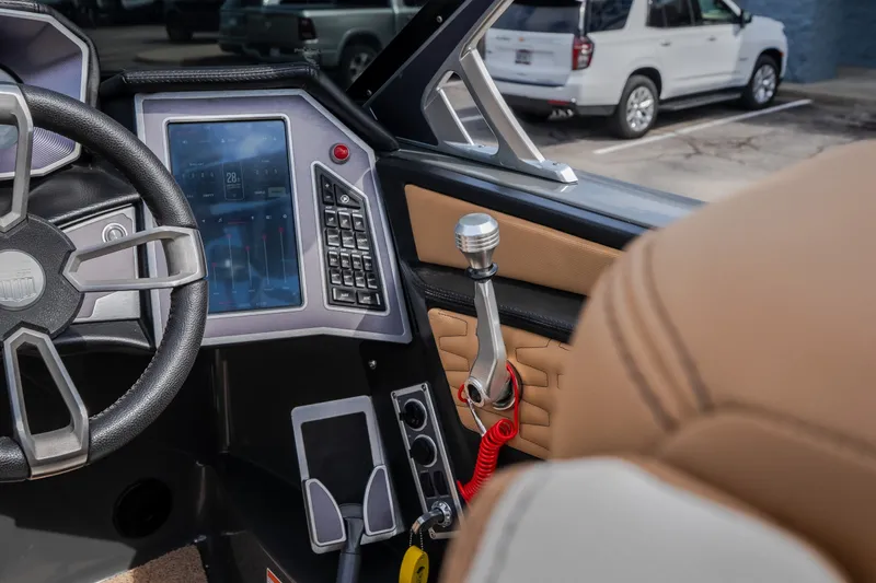 Slide: The Image of Interior of a 2021 MasterCraft X24 boat featuring a modern dashboard and steering wheel. - 27