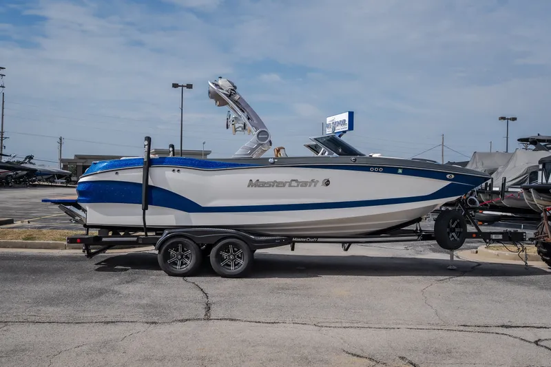 Slide: The Image of 2021 MasterCraft X24 boat on trailer in parking lot, side view. - 10