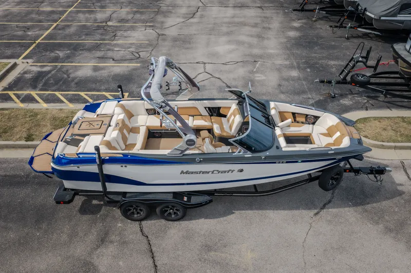 Slide: The Image of 2021 MasterCraft X24 boat on trailer, parked in a lot, aerial view. - 55