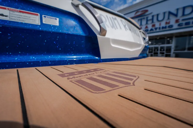 Slide: The Image of 2021 MasterCraft X24 boat with teak deck, displayed at a marine center. - 9
