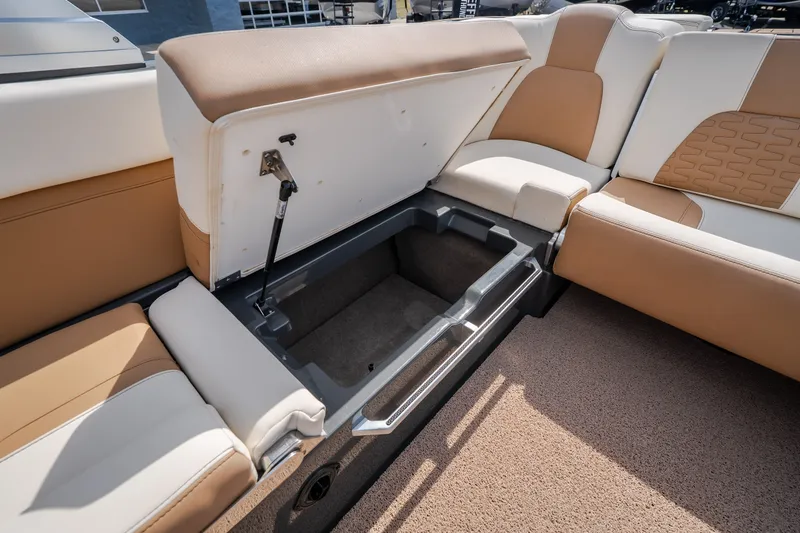 Slide: The Image of 2021 MasterCraft X24 boat with open storage compartment under tan and white seating. - 42