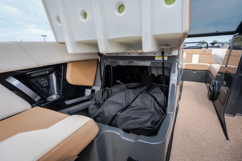 Slide: The Image of 2021 MasterCraft X24 boat interior storage compartment with beige and black seating. - 31