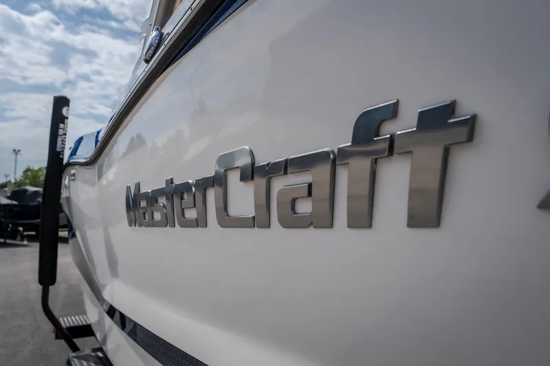 Slide: The Image of 2021 MasterCraft X24 boat with sleek branding on the side under a cloudy sky. - 7