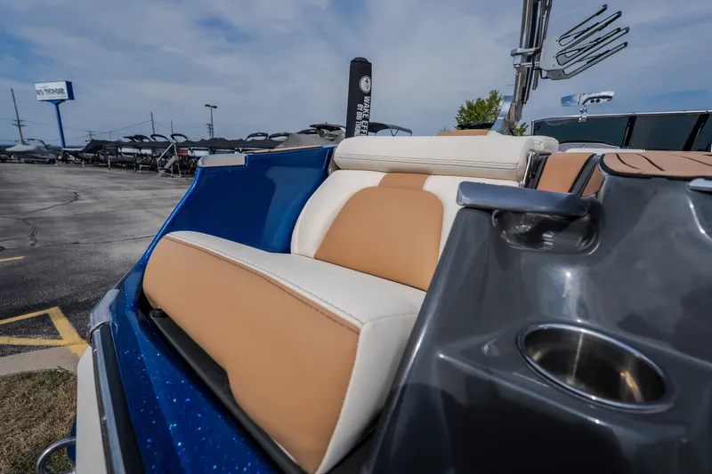 Slide: The Image of 2021 MasterCraft X24 boat interior with tan and white seating, cup holder, and sleek design. - 17