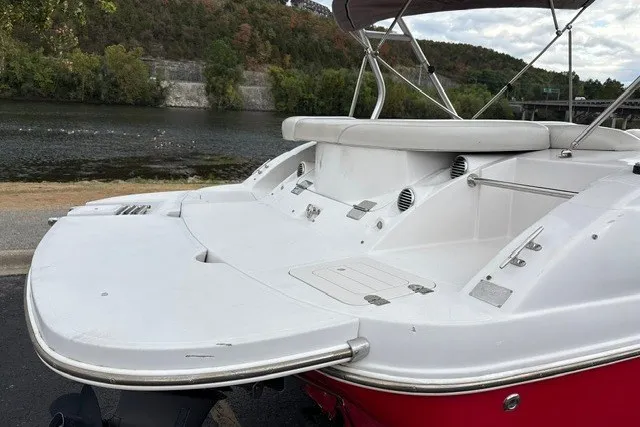 Slide: The Image of 2012 Starcraft 2000 IO Limited boat with white deck, docked by a scenic river. - 17