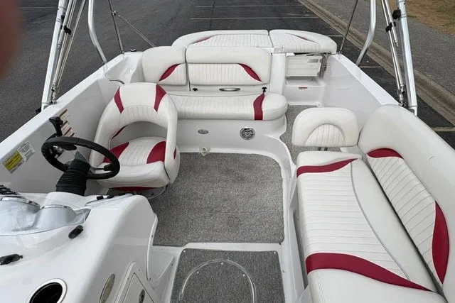 Slide: The Image of 2012 Starcraft 2000 IO Limited boat interior with white and red seating, steering wheel, and carpeted floor. - 13
