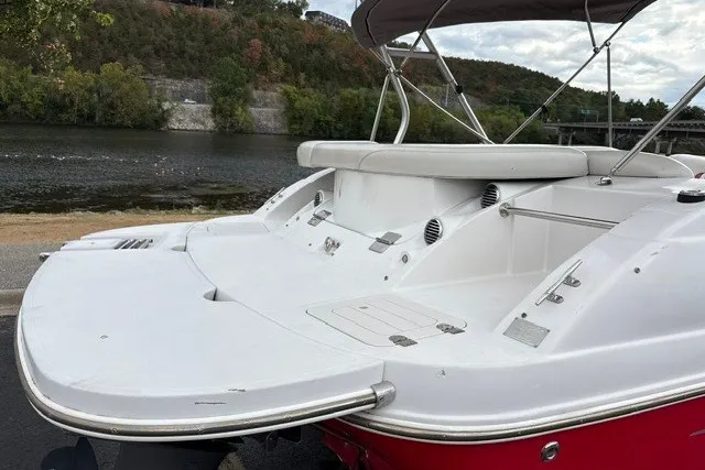 Slide: The Image of 2012 Starcraft 2000 IO Limited boat with white deck, docked by a scenic river. - 19
