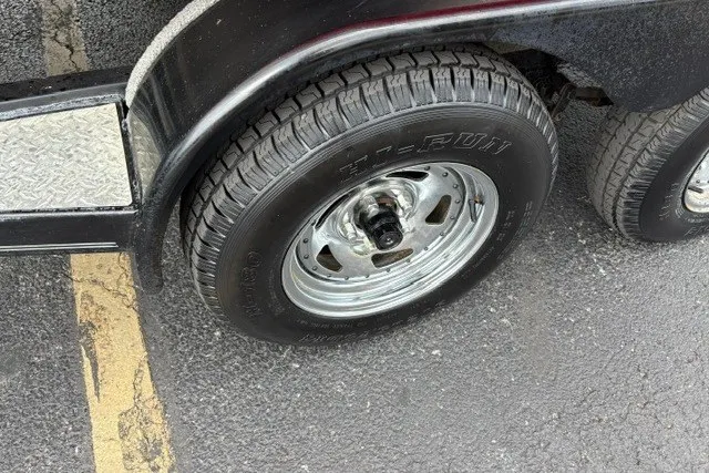 Slide: The Image of Trailer wheel of a 2012 Starcraft 2000 IO Limited on asphalt pavement. - 39