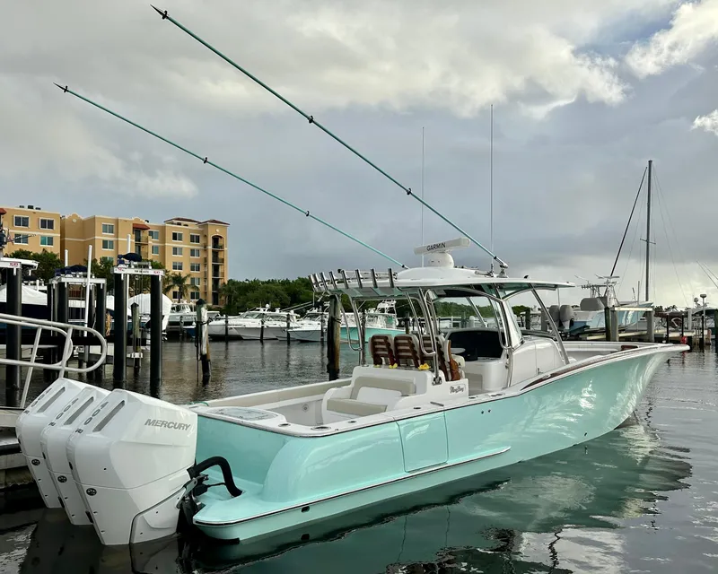 Slide: The Image of 2025 Mag Bay 38 CC boat docked with twin Mercury engines, marina background. - 4
