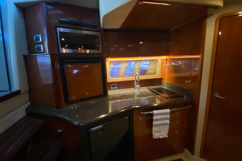 Slide: The Image of 2006 Sea Ray 38 Sundancer yacht kitchen with wood cabinetry and modern appliances. - 21