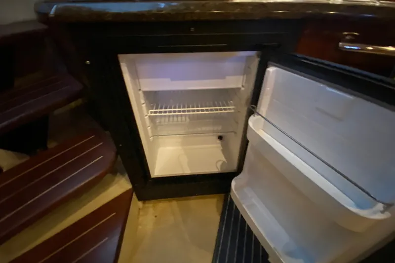 Slide: The Image of Open refrigerator inside 2006 Sea Ray 38 Sundancer yacht, showcasing interior storage space. - 24