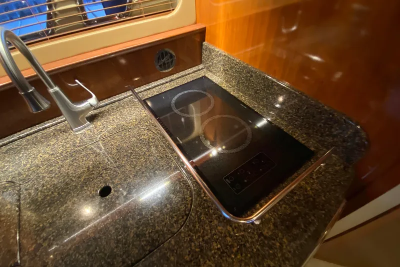 Slide: The Image of Luxury kitchen area in 2006 Sea Ray 38 Sundancer yacht with sleek countertop and stove. - 27