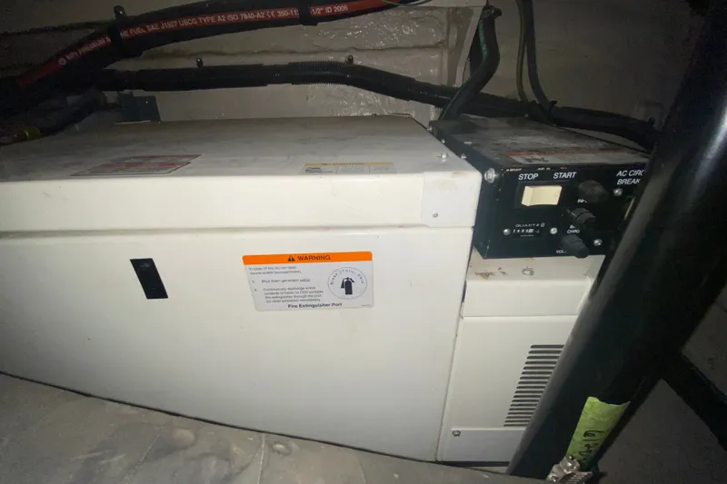 Slide: The Image of Engine compartment of a 2006 Sea Ray 38 Sundancer with generator controls and warning label. - 47
