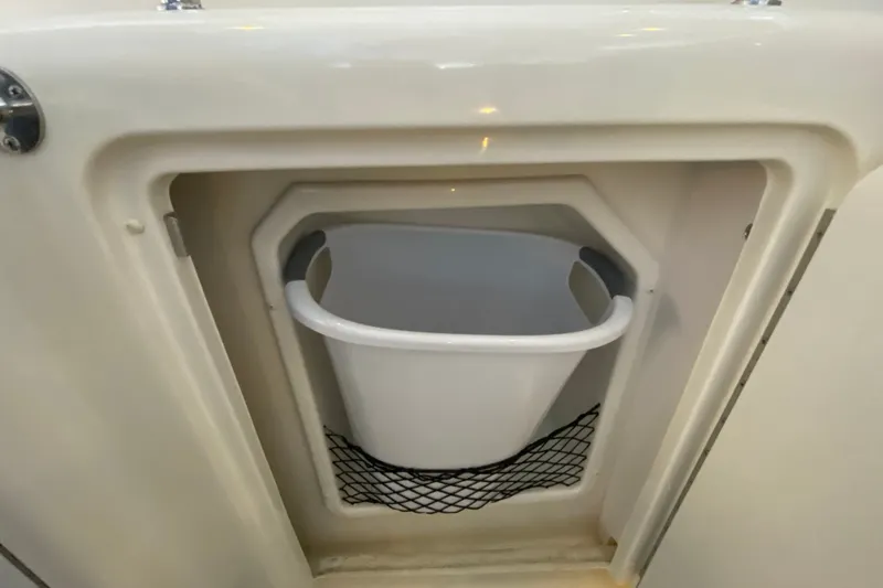 Slide: The Image of Storage compartment with a white bucket on a 2006 Sea Ray 38 Sundancer boat. - 13