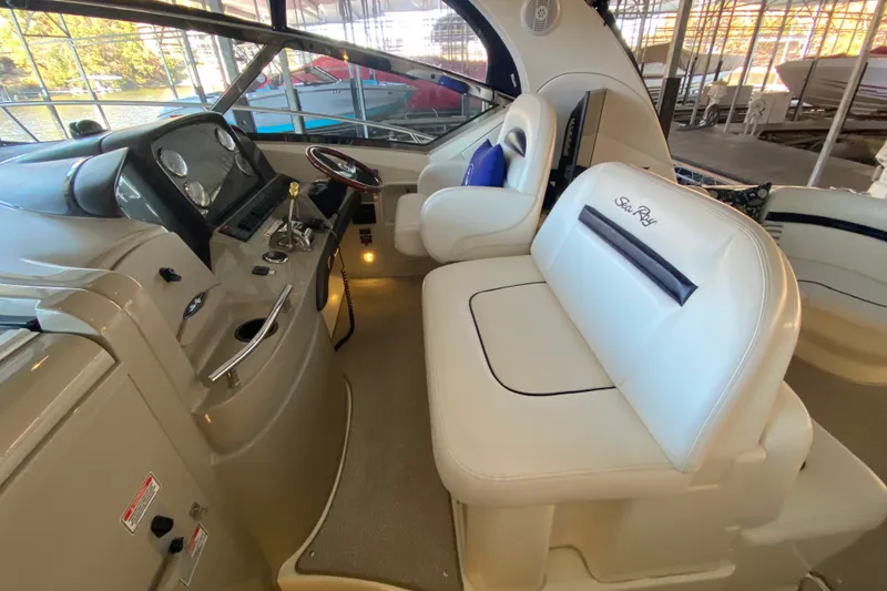 Slide: The Image of 2006 Sea Ray 38 Sundancer helm with white leather seating and modern controls. - 14