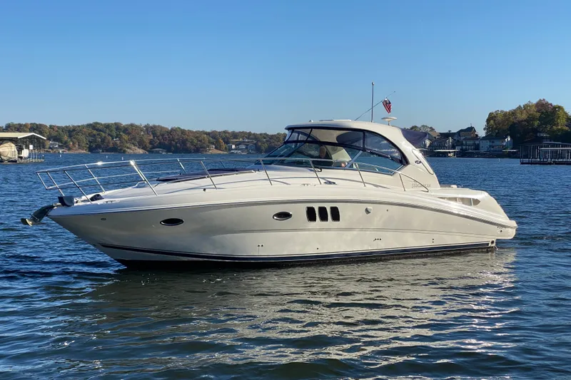 The Image of 2006 Sea Ray 38 Sundancer yacht on calm water, clear sky, scenic background. - 1
